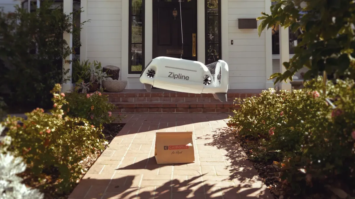Zipline Platform 2 drone lowering a Chipotle food order via tether in a residential Texas neighborhood