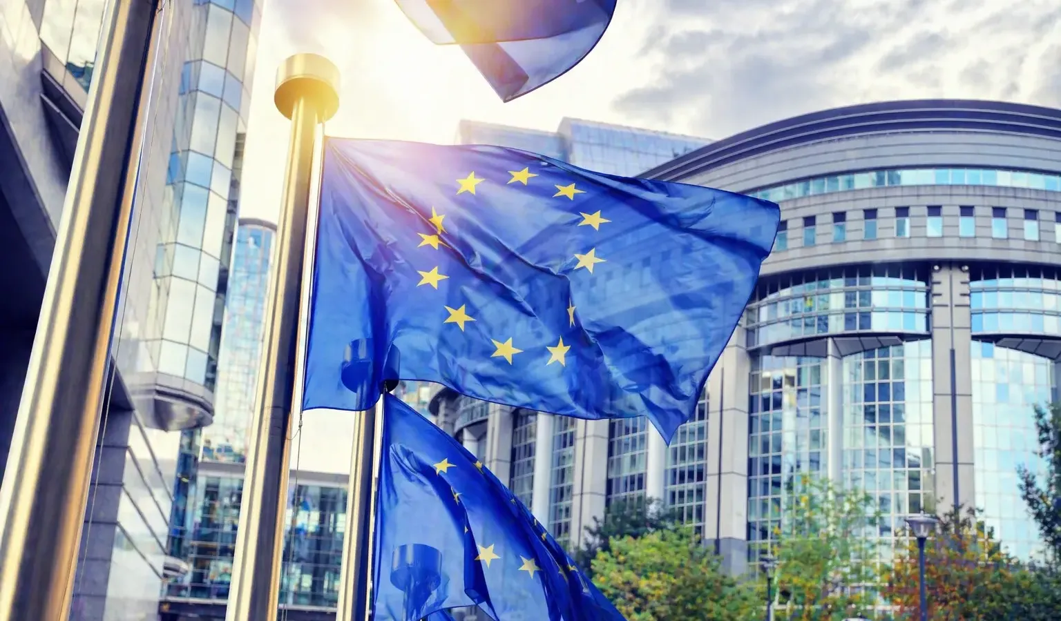 European Commission headquarters in Brussels with EU flags, representing the European Defence Fund announcement