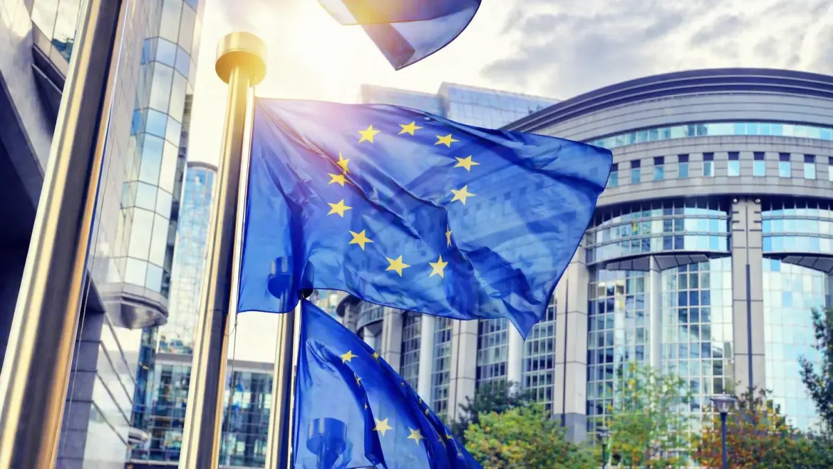 European Commission headquarters in Brussels with EU flags, representing the European Defence Fund announcement