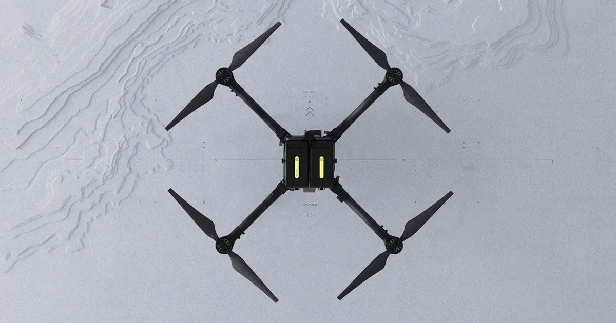 Freefly Astro quadcopter seen from directly above, with two batteries in its centre, on a pale topographic background