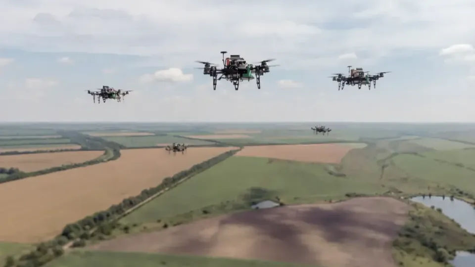 Multiple FPV drones flying in coordinated formation over a Ukrainian battlefield landscape