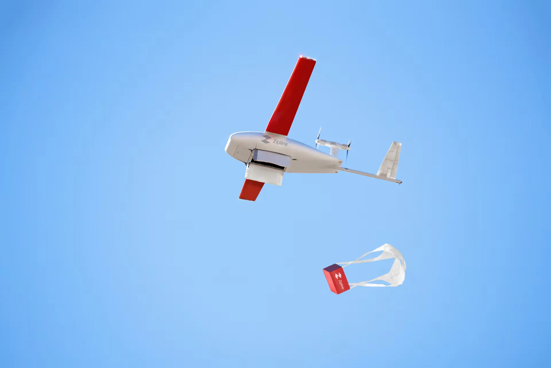 Zipline Platform 2 drone lowering a tethered package to a residential driveway
