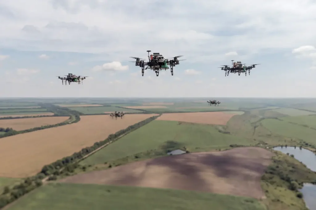 Multiple FPV drones flying in coordinated formation over a Ukrainian battlefield landscape